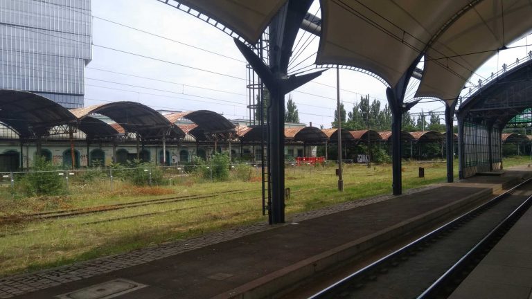 Widok na zabytkowe wiaty oraz tory kolejowe.