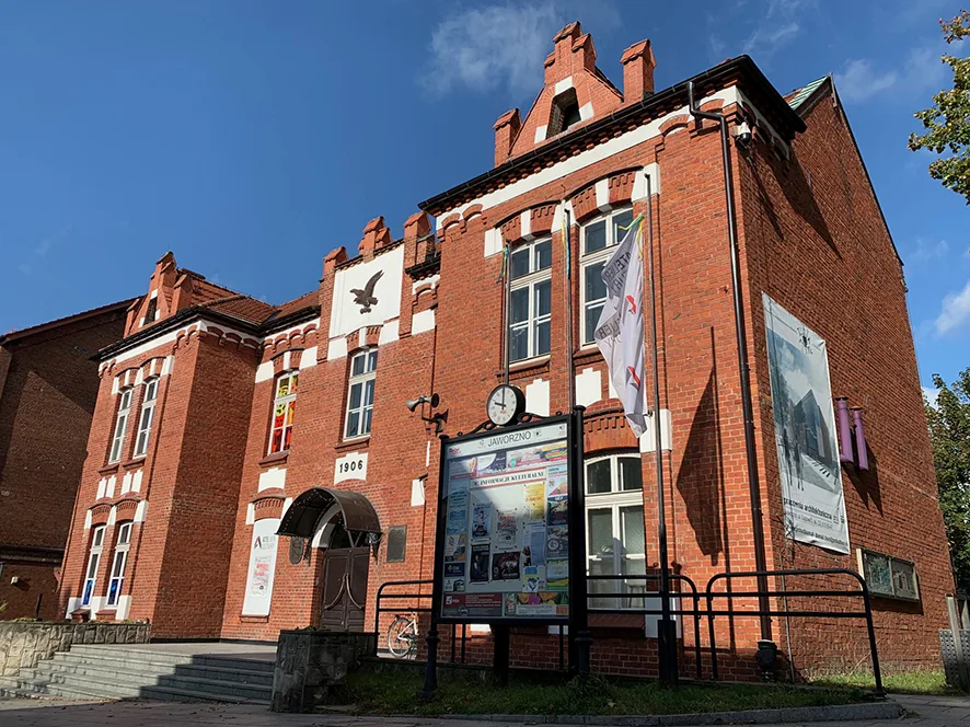Widok budynku z czerwonej cegły od zewnątrz.