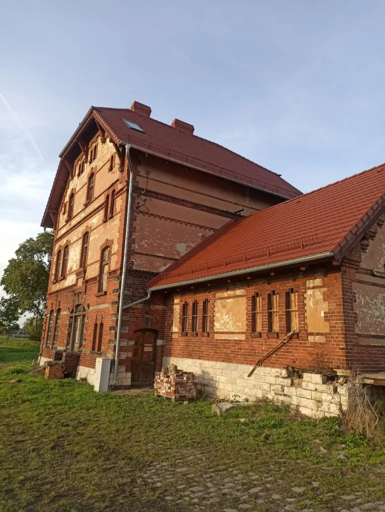 Widok budynku z czerwonej cegły w promieniach zachodzącego słońca.