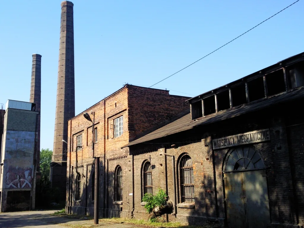 Widok industrialnych budynków z zewnątrz.