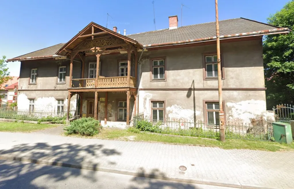Zabytkowy budynek w otoczeniu zieleni.