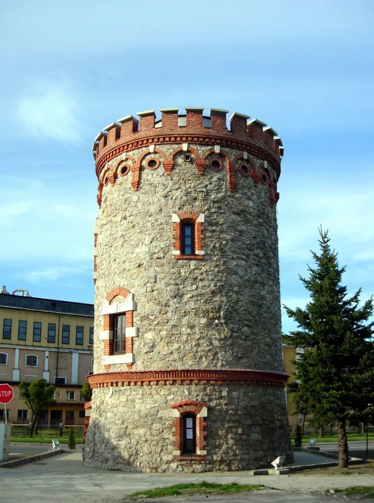 Kamienno - ceglana baszta na tle miasta.