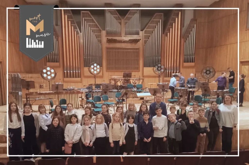 zdjęcie grupowe w filharmonii; w lewym górnym rogu logo programu most the music