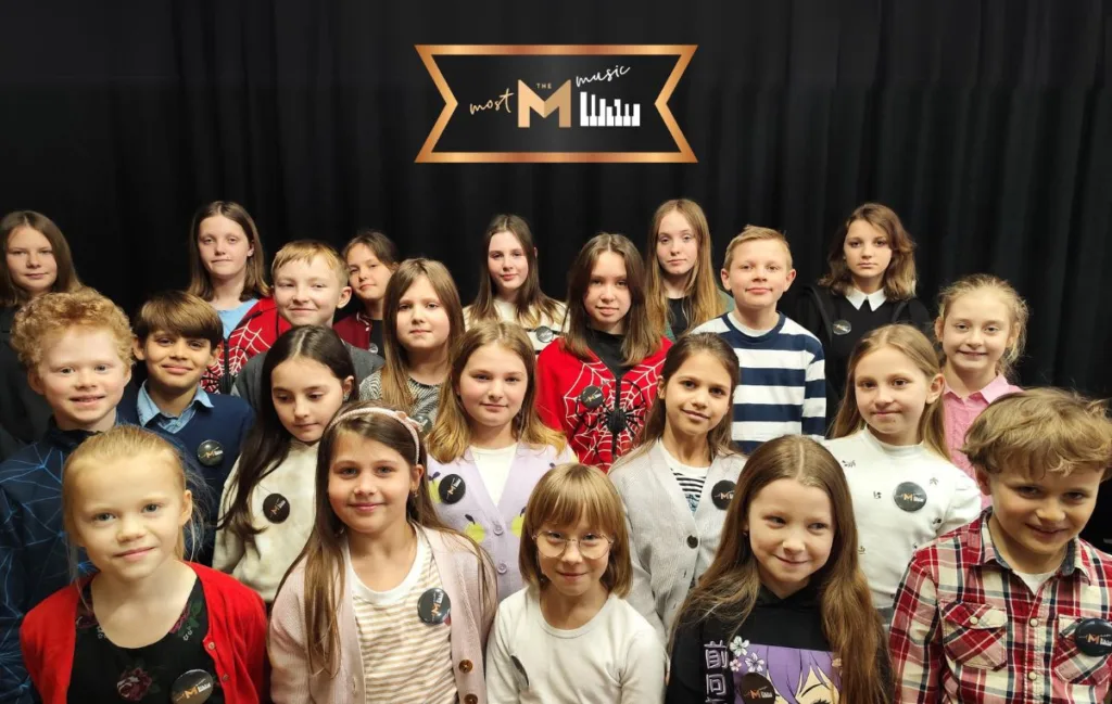 Zdjęcie grupowe - uśmiechnięte dziewczęta i chłopcy.